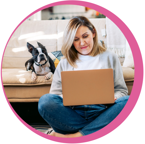 Dog sitting next to woman on laptop