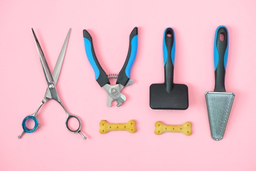 Pet care and grooming tools on a pink background.